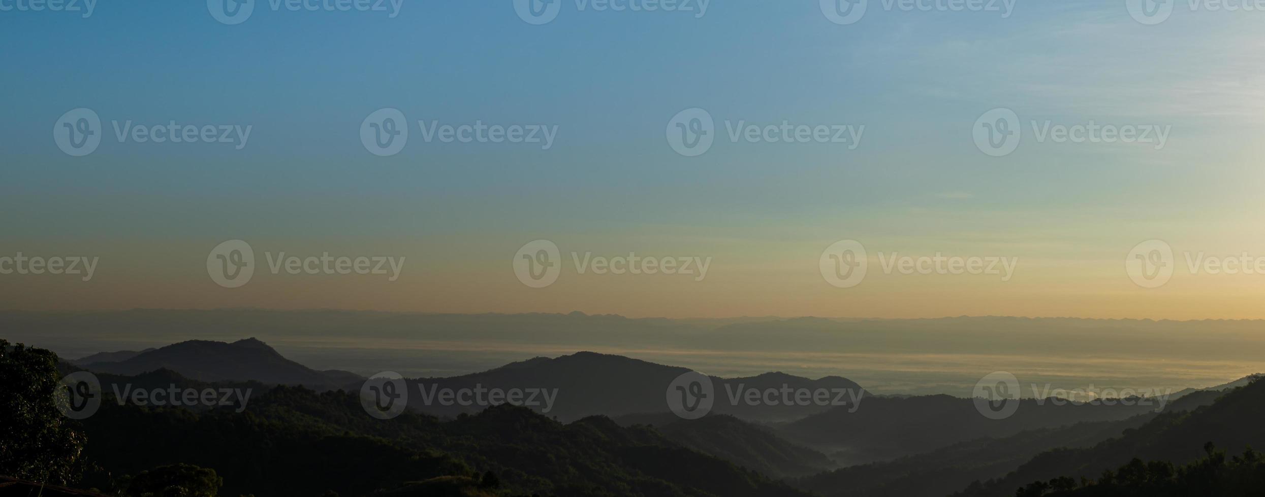 Silhouette of mountains during sunrise with sky and clouds. Beautiful natural landscape in the summertime photo