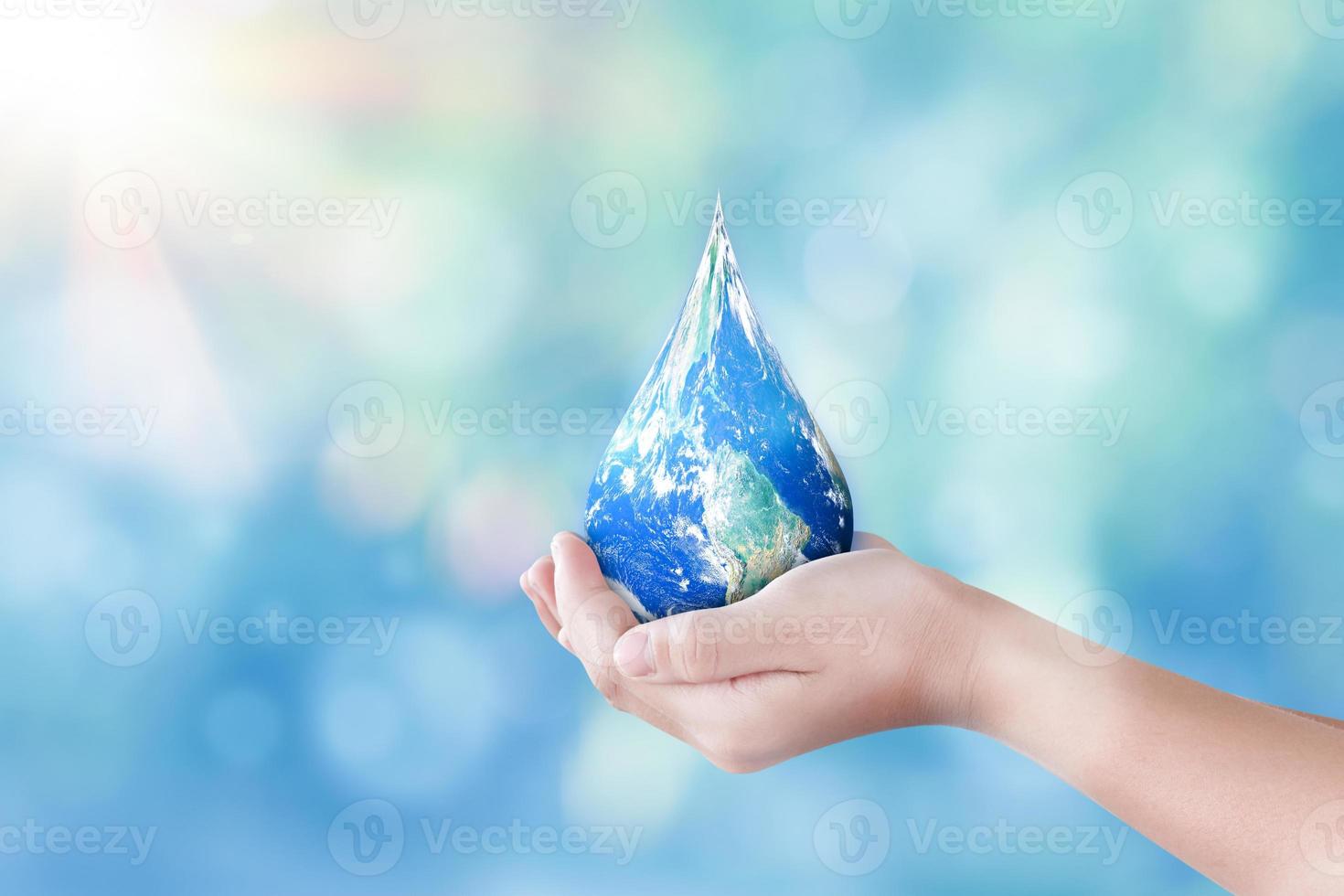 Hands holding global in drop shape on blurred nature background. World day for water and sustain for earth concept. Elements of this image furnished by NASA photo