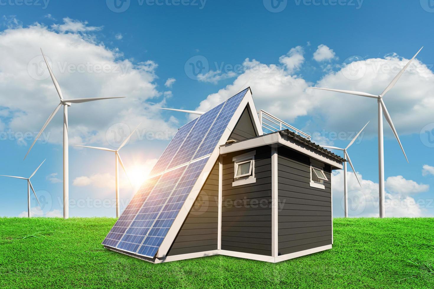 Solar panels on a house roof on green grass with wind turbine and blue sky background. alternative electricity source - sustainable resources concept. photo