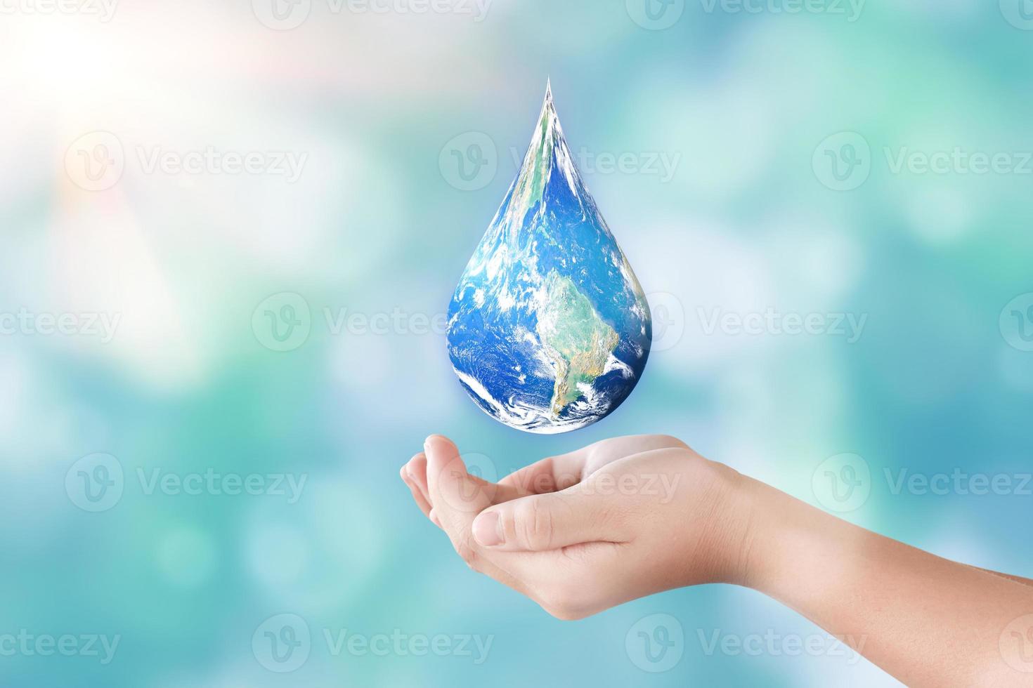 manos sosteniendo global en forma de gota sobre fondo de naturaleza borrosa. día mundial del agua y sustentar el concepto de la tierra. elementos de esta imagen proporcionados por la nasa foto