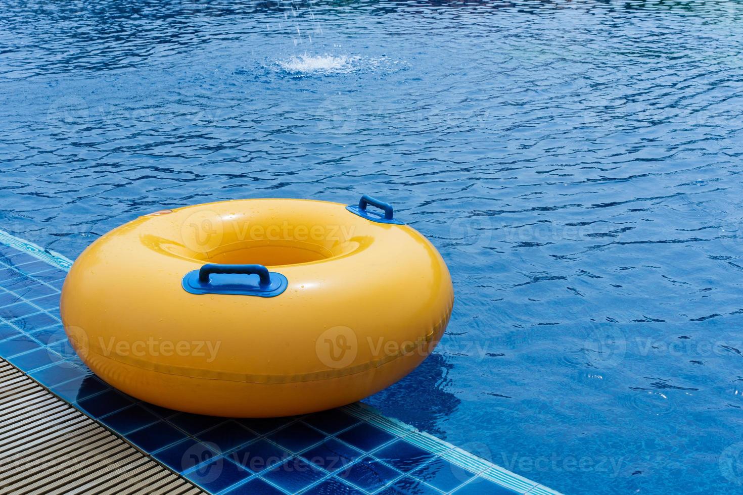 Yellow floating ring in swimming pool. Rubber ring swimming. Summer concept. photo