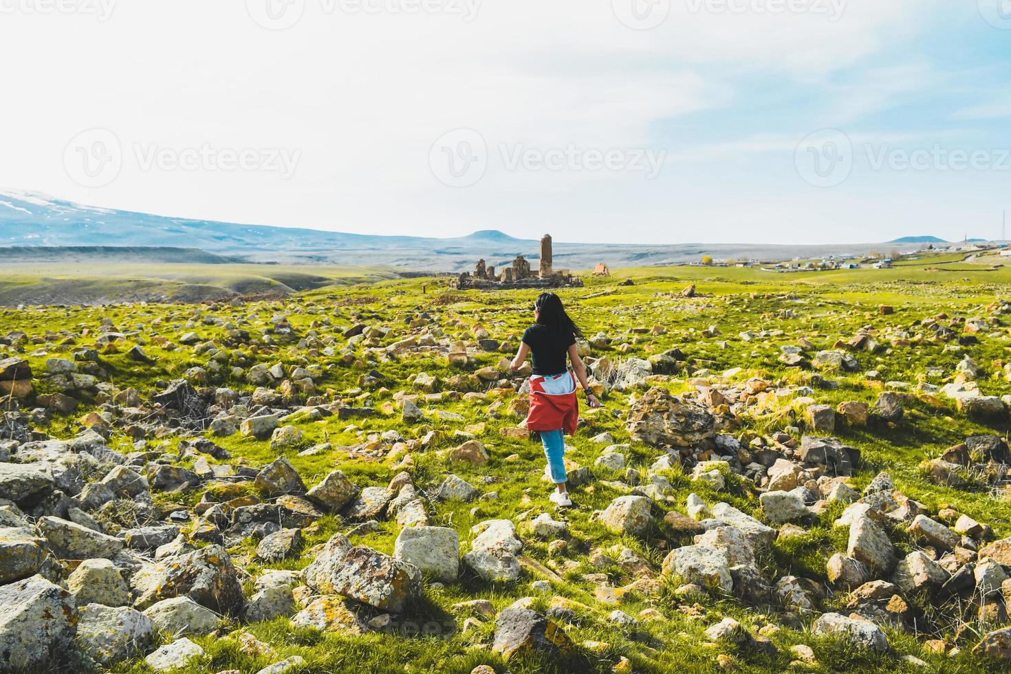 una turista caucásica camina por las ruinas de ani haciendo turismo en primavera. destino de viaje en kars foto