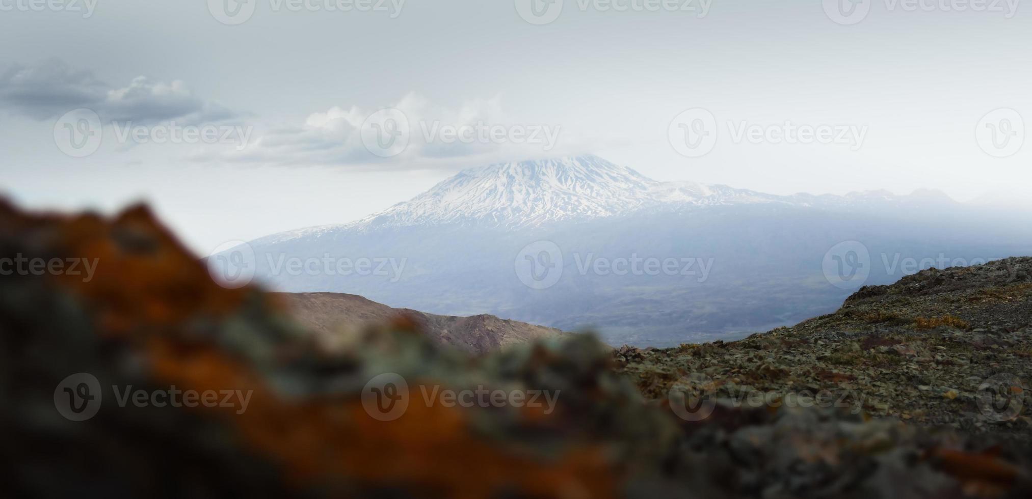 Snowy mountain ararat peak with cloud pass from Turkey side in late spring. At the foot of mt Ararat photo