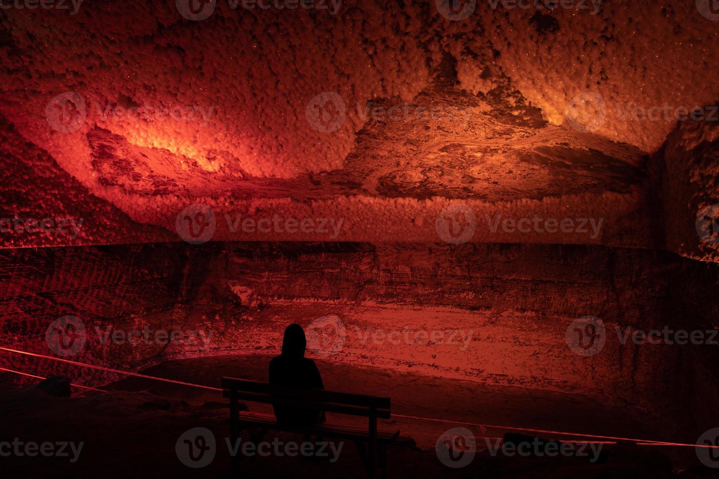 Person sit alone on bench in tourist destination - Tuzluca cave in Turkey. Solo travel exploration concept photo