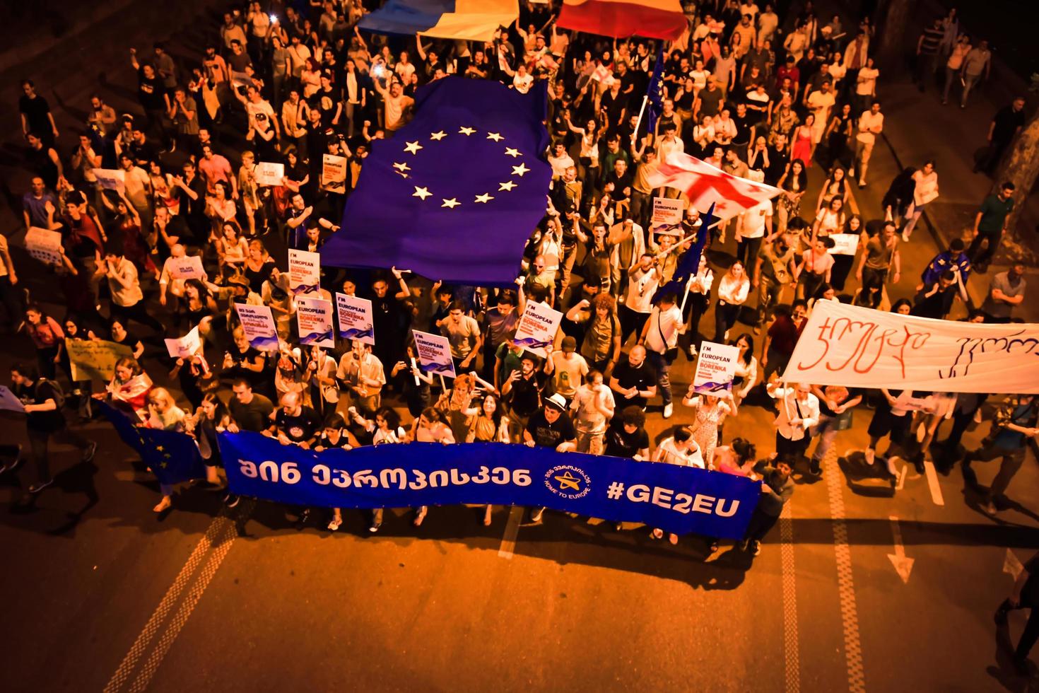 Tbilisi, Georgia , 2022 - Aerial view people march in streets on major EU-pro rally event. Thousands of people on peaceful demonstration event. Pro-Europe rally event in capital city Georgia photo