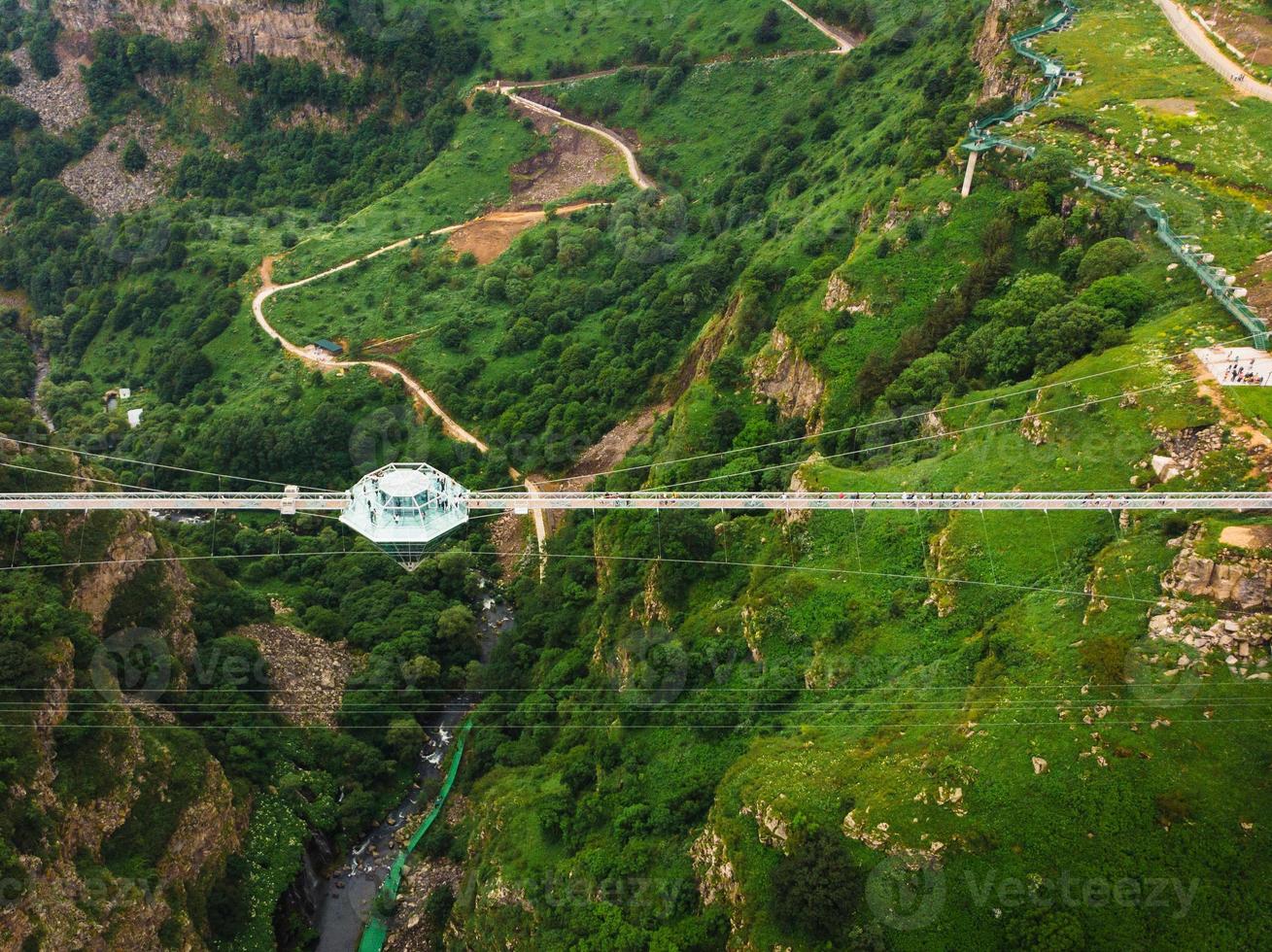 Dashbashi, Georgia , 2022 - Aerial fly over Diamond shape platform on glass bridge over scenic dashbashi valley in Georgia countryside. Famous modern bridge over valley in caucasus photo