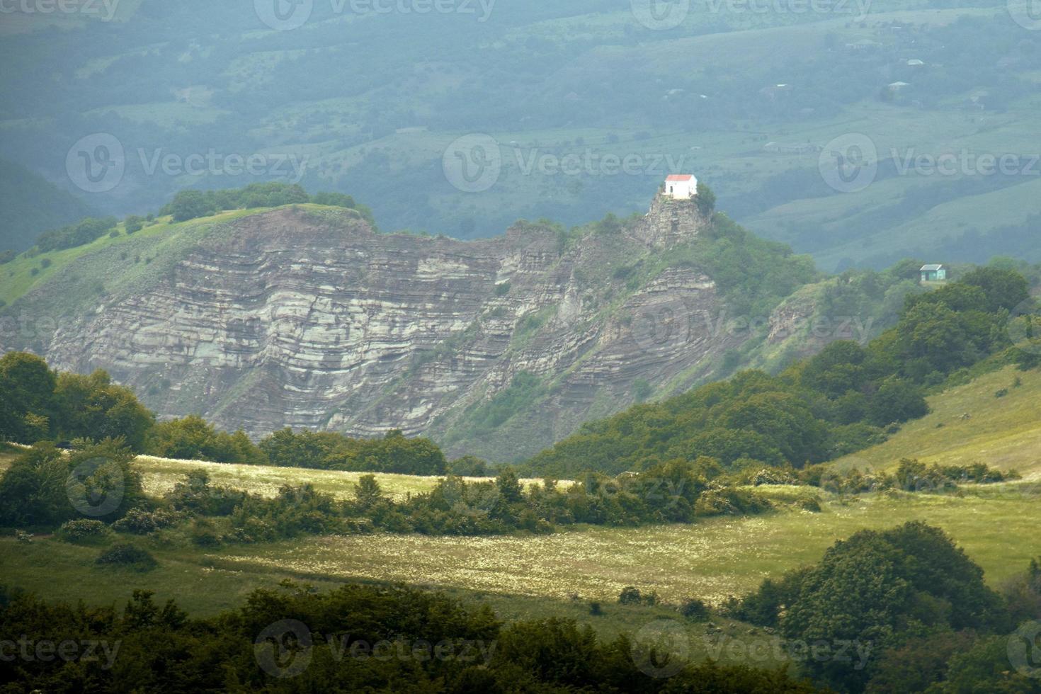 capilla blanca en la cima de una colina en el campo de georgia cáucaso tbilisi a la carretera de las montañas didgori foto