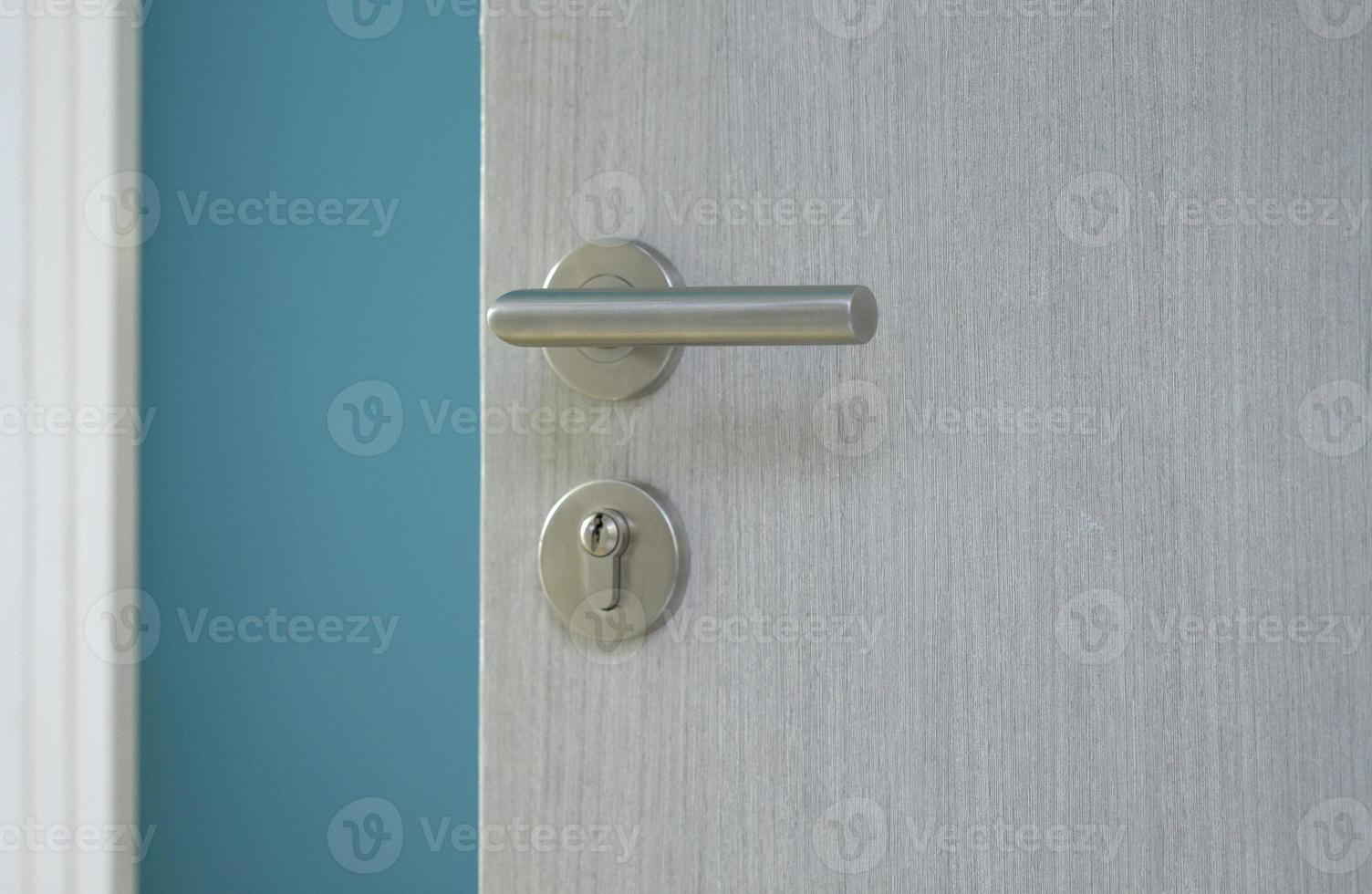 Opened door with metal door knob into blue room photo