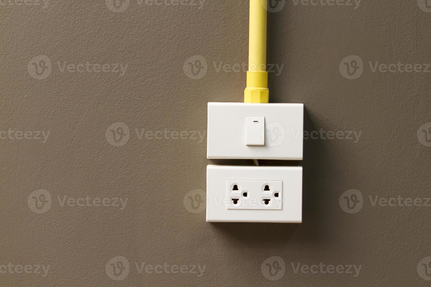 Electric light switch and socket on the empty wall photo