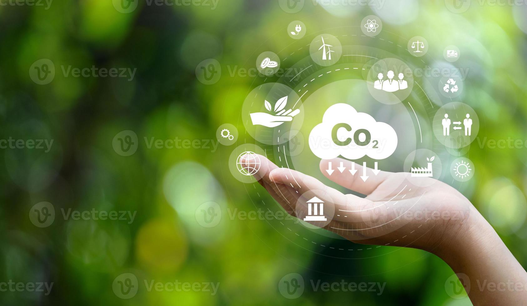 CO2 emission reduction concept in hand with environmental icons, global warming, sustainable development, connectivity and renewable energy green business background. photo