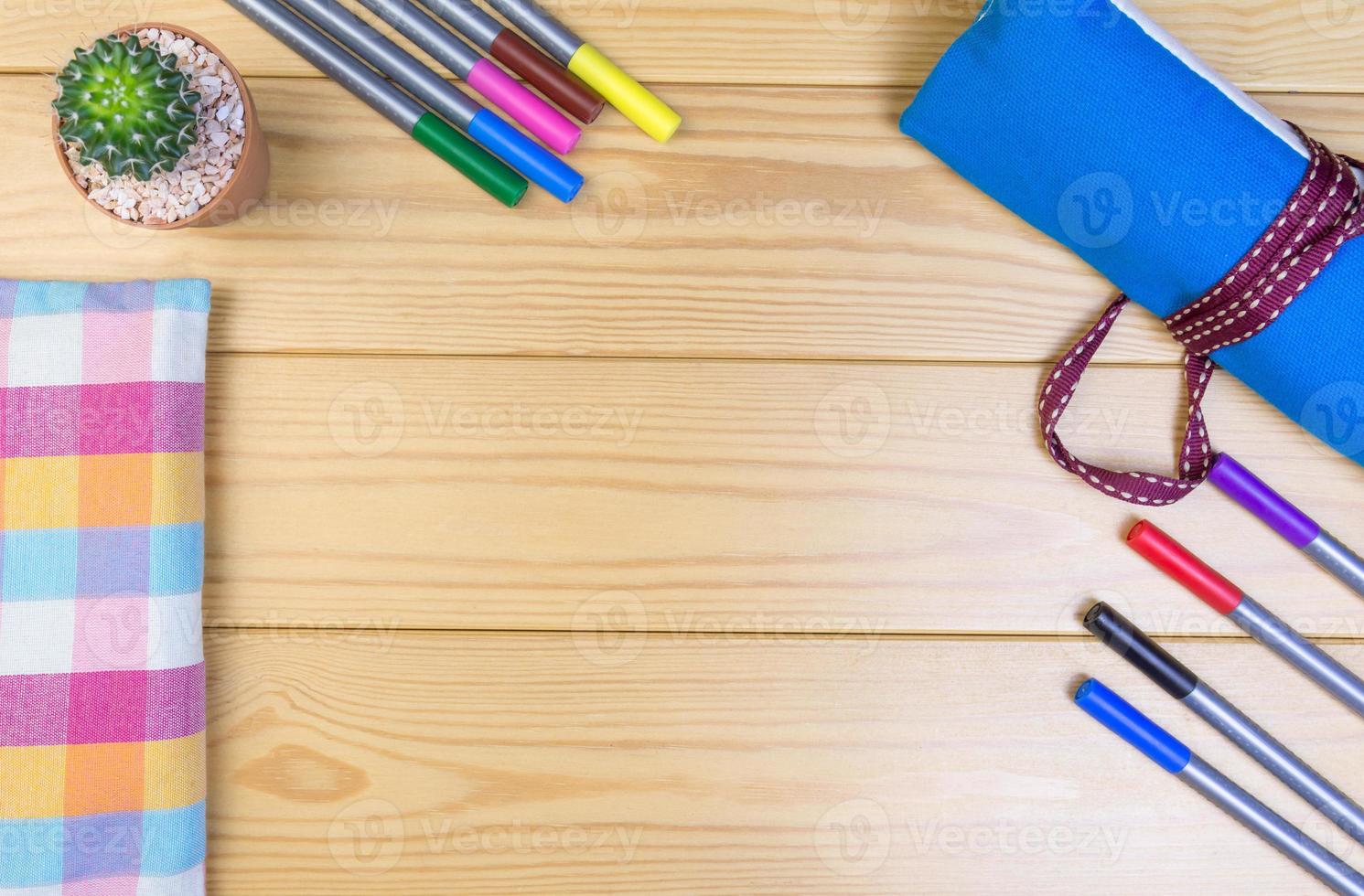 Magic colored pens, cloth bag, cactus on the wooden table. photo