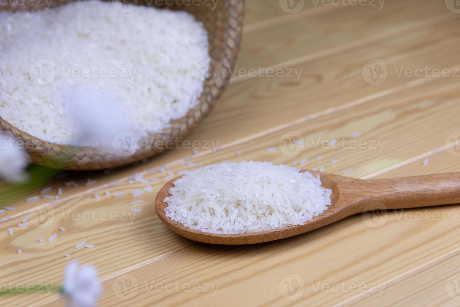 Rice in a wooden ladle background  is a container basket weave on wooden table. photo