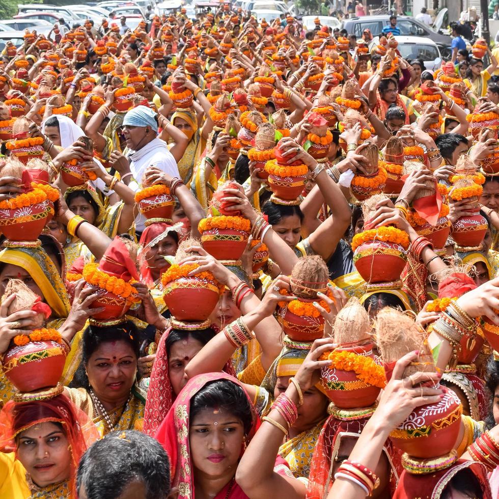 New Delhi, India April 03 2022 - Women with Kalash on head during Jagannath Temple Mangal Kalash Yatra, Indian Hindu devotees carry earthen pots containing sacred water with a coconut on top photo
