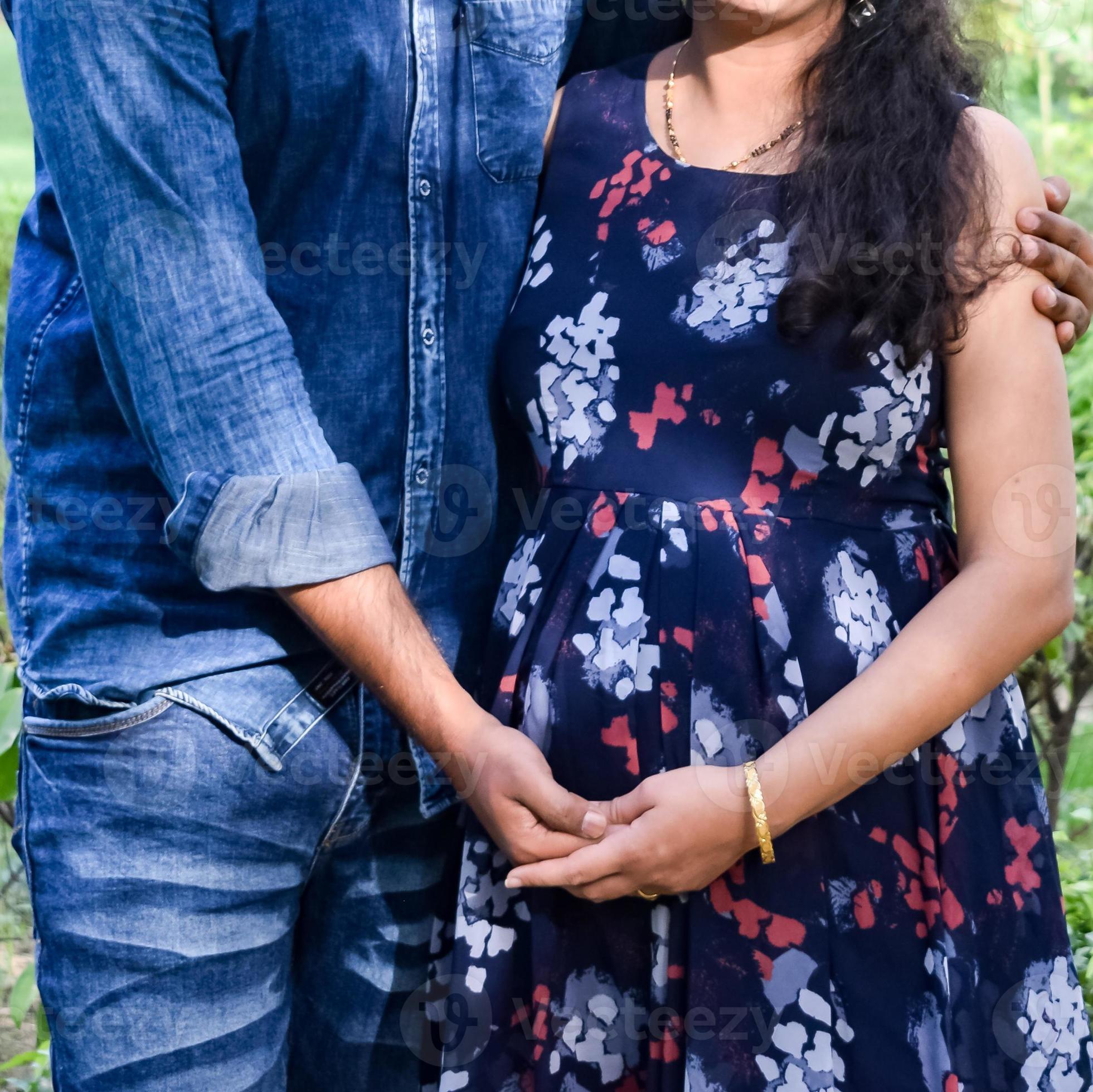 Young asian indian pregnant woman with her husband wearing traditional  outfit standing in park or garden copy space to write text. Stock Photo |  Adobe Stock