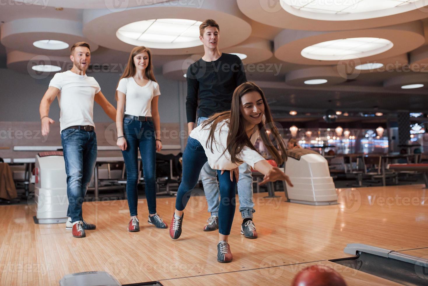 That will be nice one. Young cheerful friends have fun in bowling club at their weekends photo