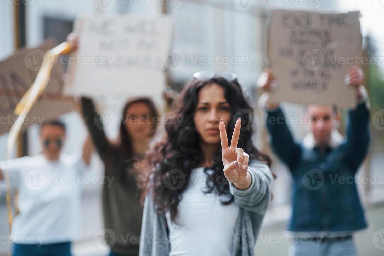 Showing gesture by two fingers. Group of feminist women have protest for their rights outdoors photo