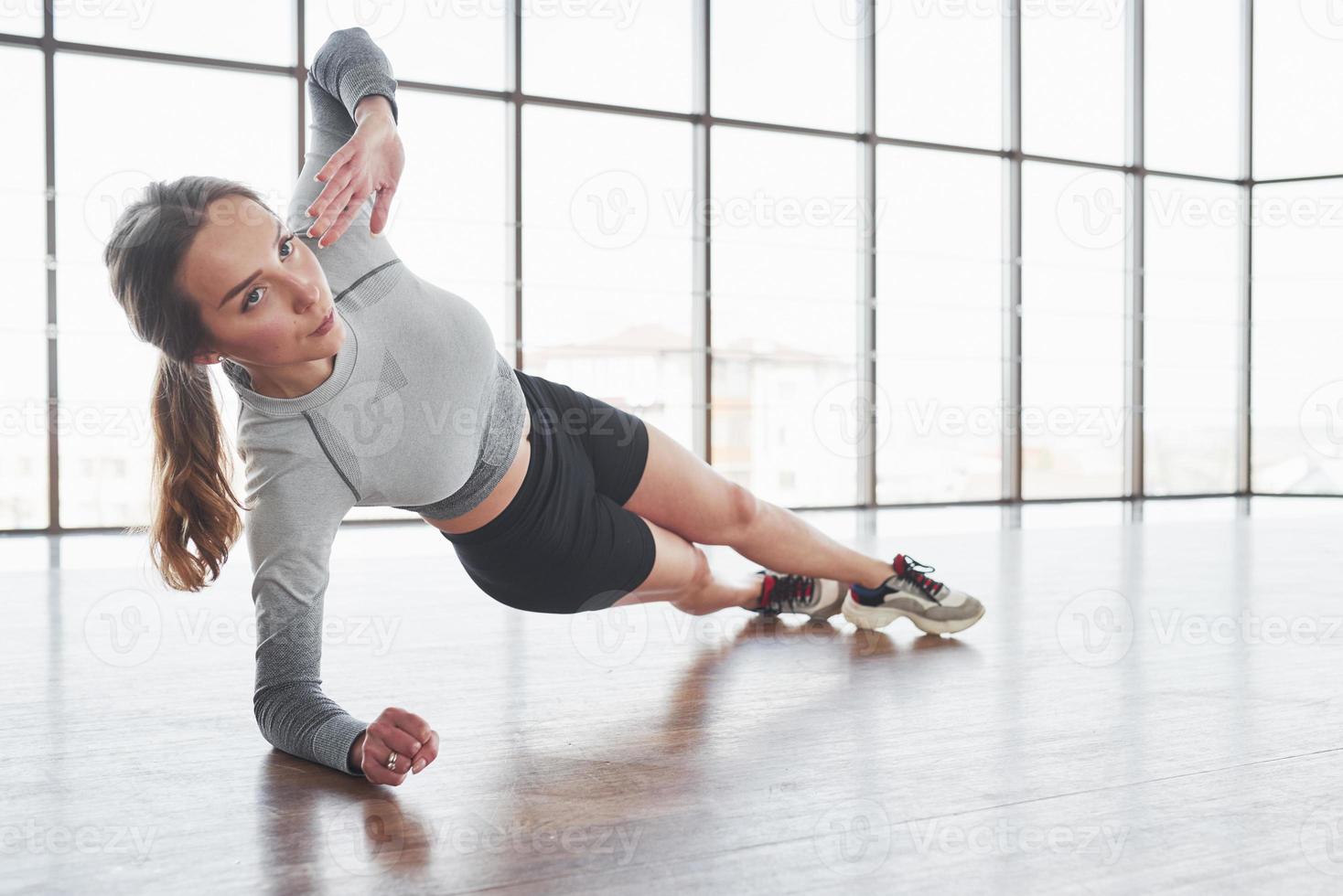 Exercises for strength and stamina. Sportive young woman have fitness day in the gym at morning time photo