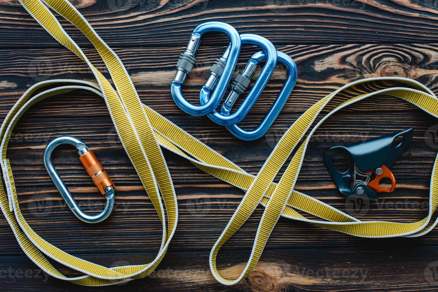 All kind of security tools. Isolated photo of climbing equipment. Parts of carabiners lying on the wooden table
