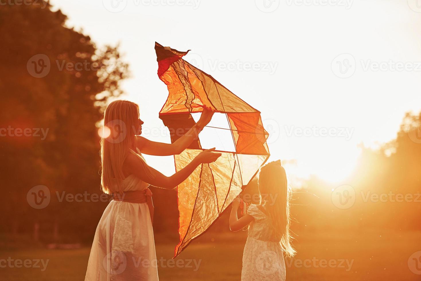 Get ready. Mother and daughter have fun with kite in the field. Beautiful nature photo