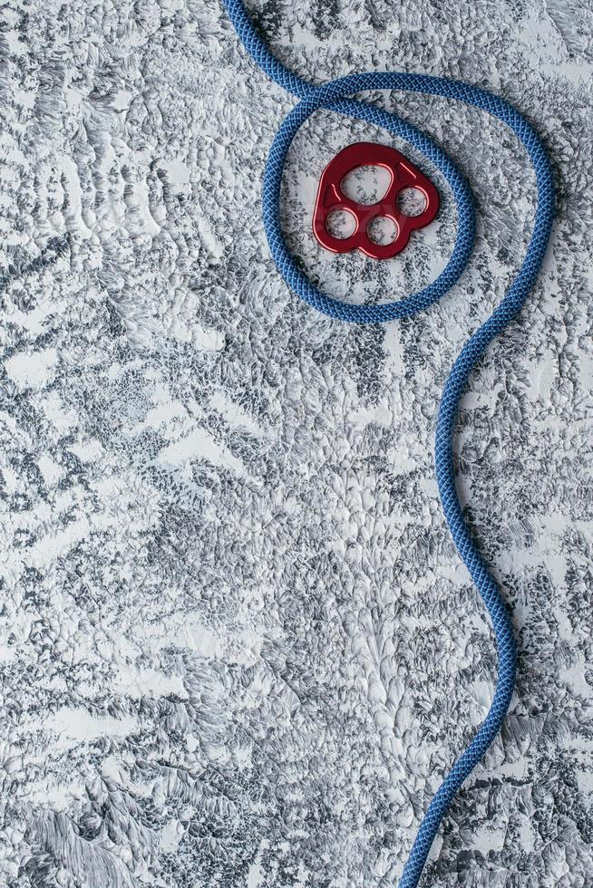 Abstract background. Isolated photo of climbing equipment. Part of carabiner lying on the white and grey colored table