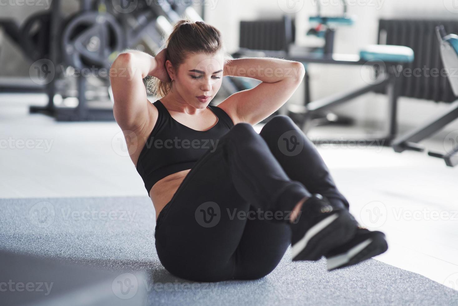 Fully concentrated at exercise. Photo of gorgeous blonde woman in the gym at her weekend time