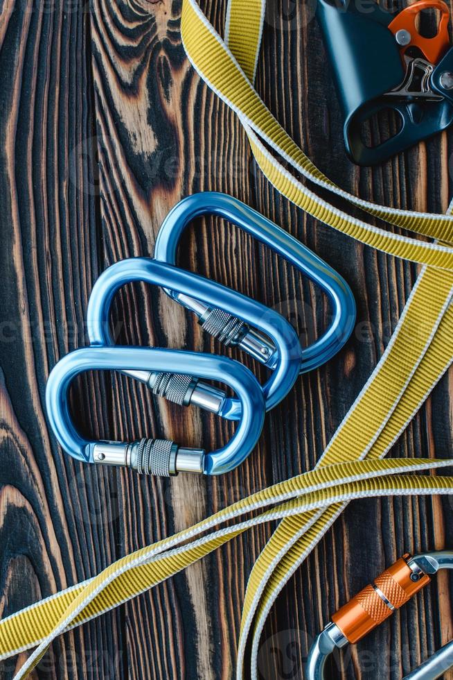Looking nice and new. Isolated photo of climbing equipment. Parts of carabiners lying on the wooden table