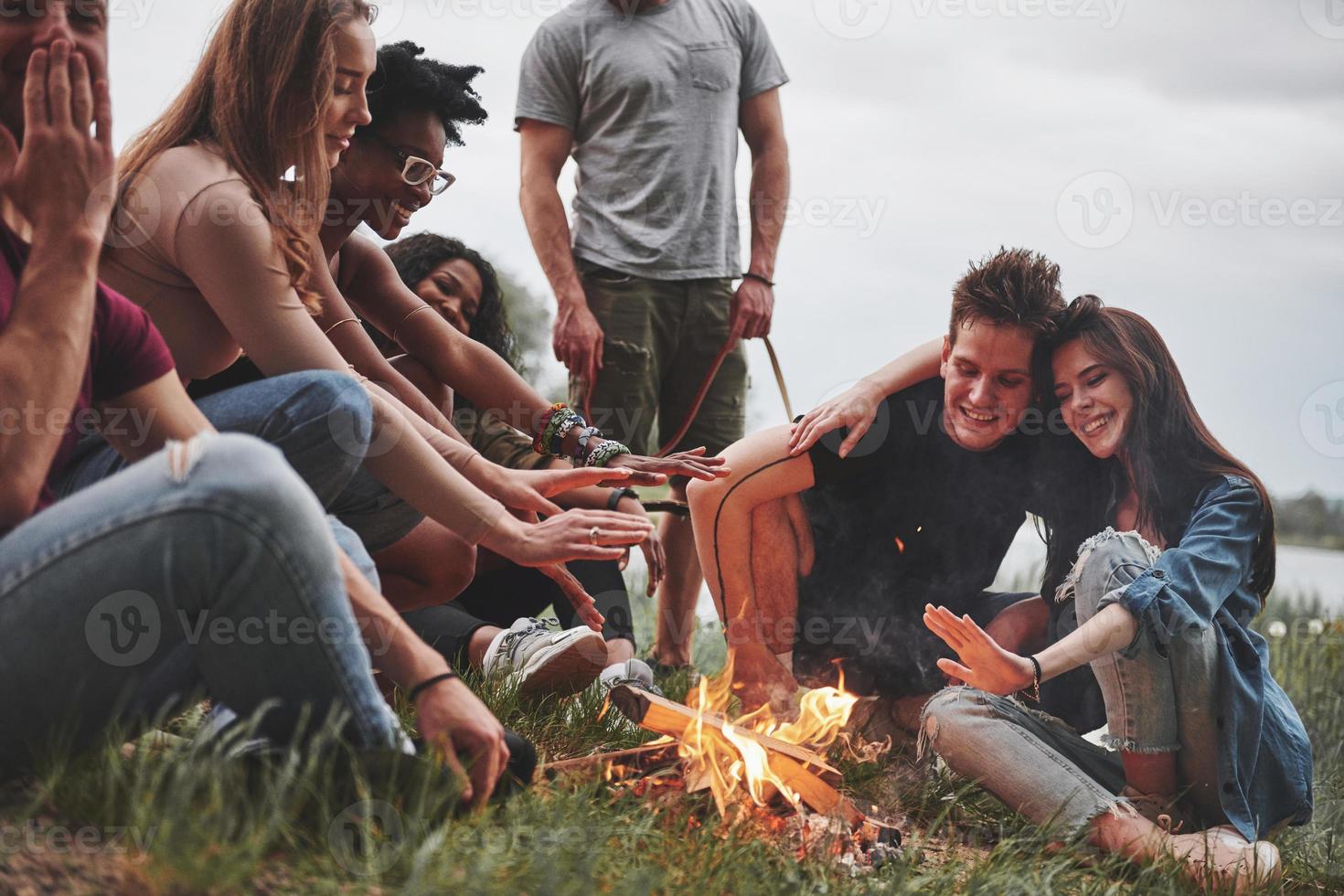 Evening at the beach. Group of people have picnic. Friends have fun at weekend time photo