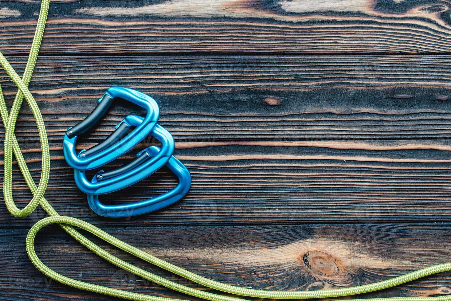 Extreme hobbies. Isolated photo of climbing equipment. Parts of carabiners lying on the wooden table