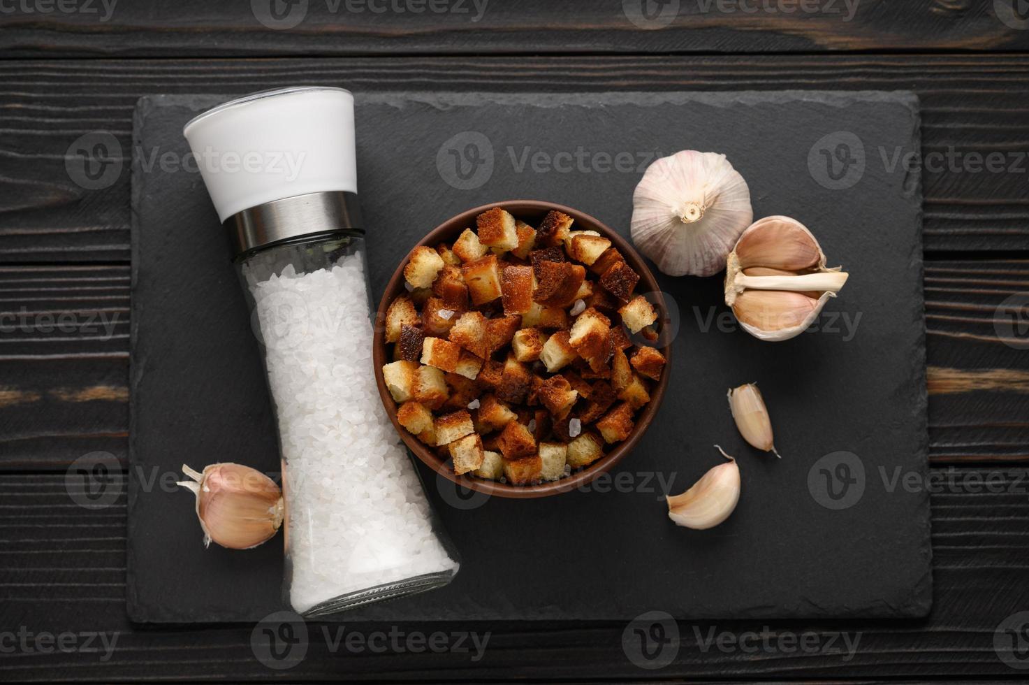 Homemade croutons with garlic and Himalayan salt on a rustic black background. photo