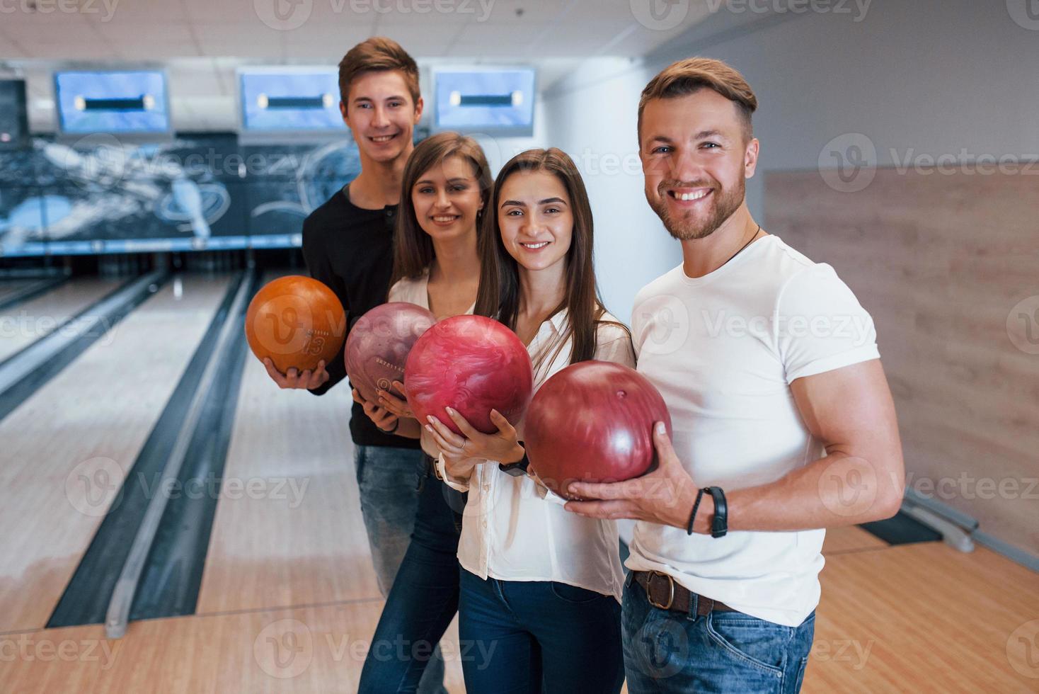 Good looking youth. Cheerful friends have fun in bowling club at their weekends photo