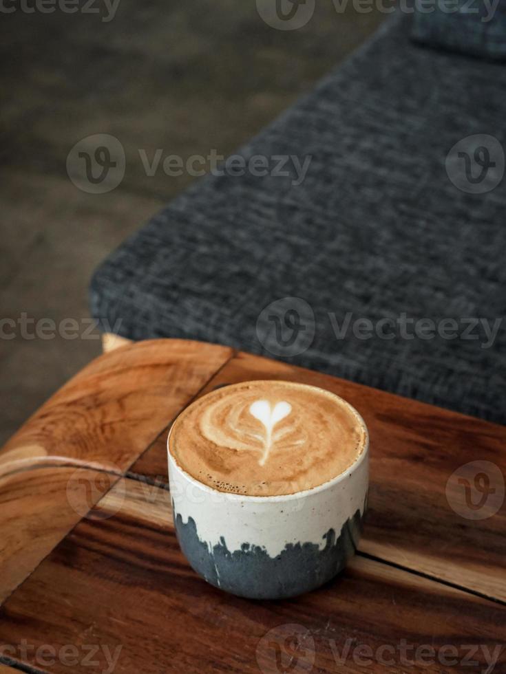 A cup of hot latte coffee on the table for breakfast photo