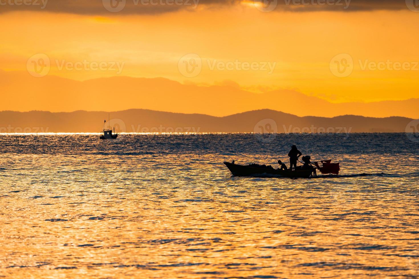 mar de tailandia en el crepúsculo con barco de silueta y pescador en el mar foto