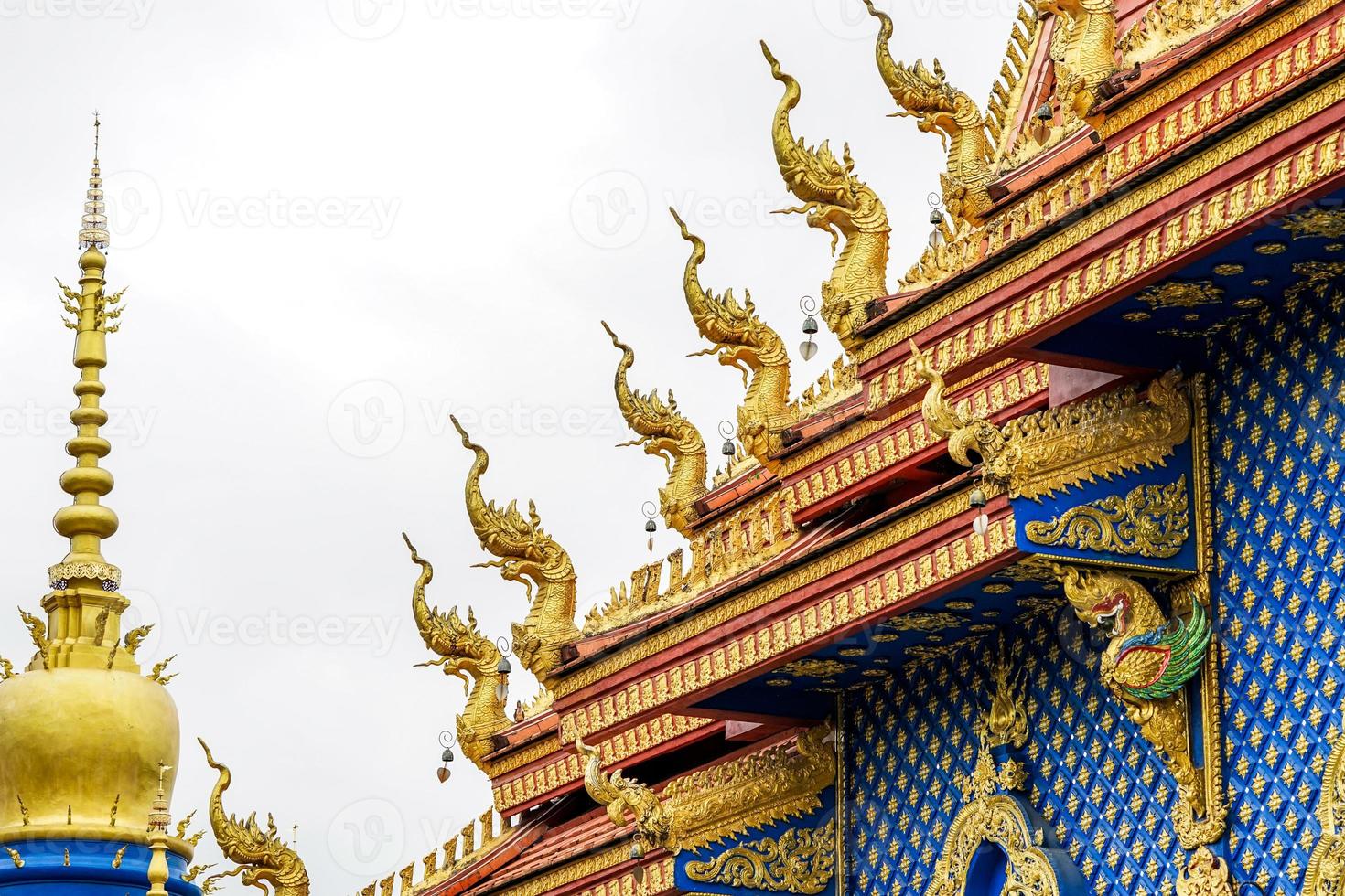 gold king of snake statue on the temple rooftop. photo
