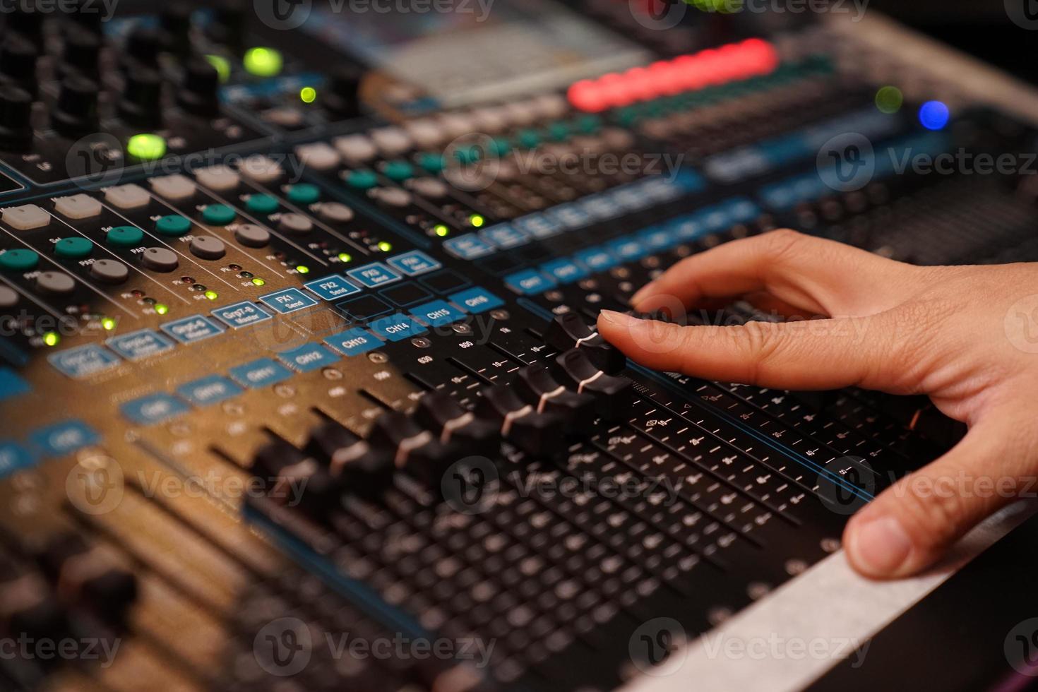 closeup to the DJ's hand with the mixer in mini concert at night. photo