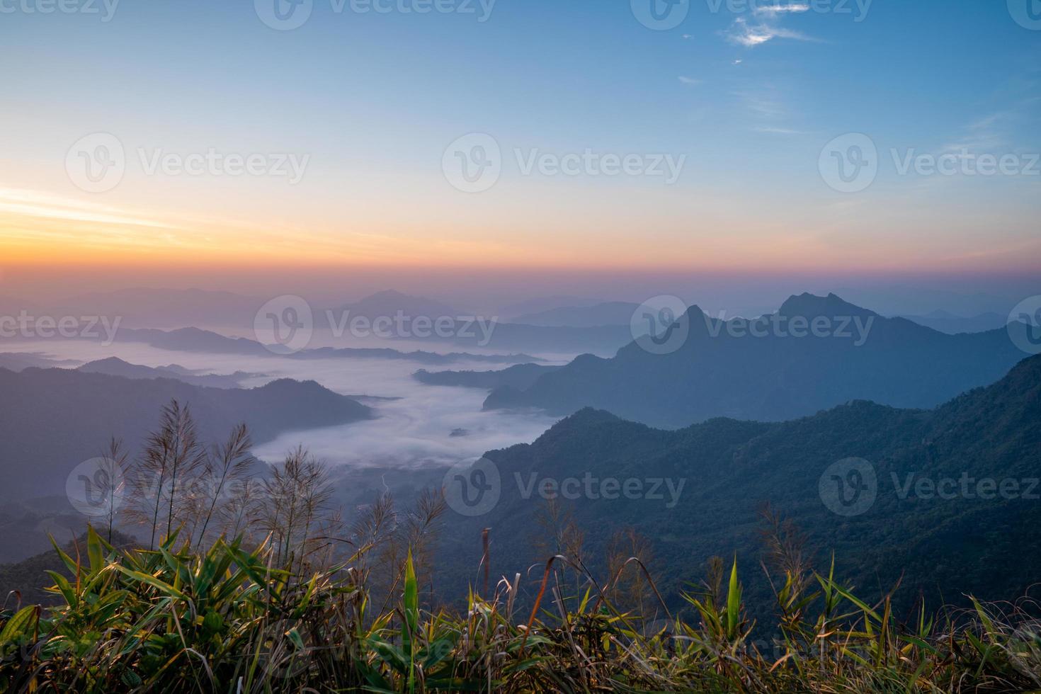 The sunrise at the mountain with the fog and cloud cover it. photo
