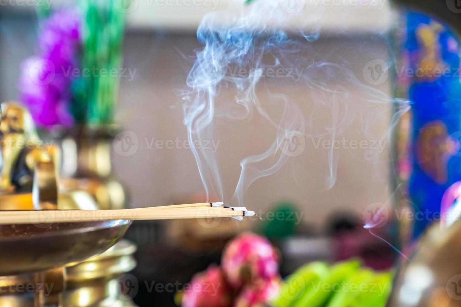 Incense on the brass candlestrick with the smoke out from incense. photo