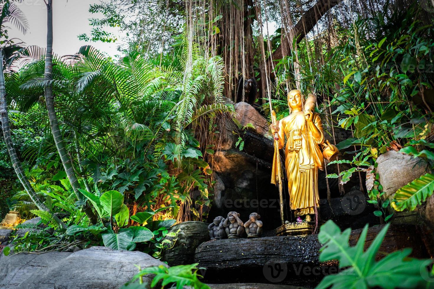 Golden follower Buddha statues walking post on the rock arrounding with plant and vine., Golden Mount, Bangkok, Thailand. photo