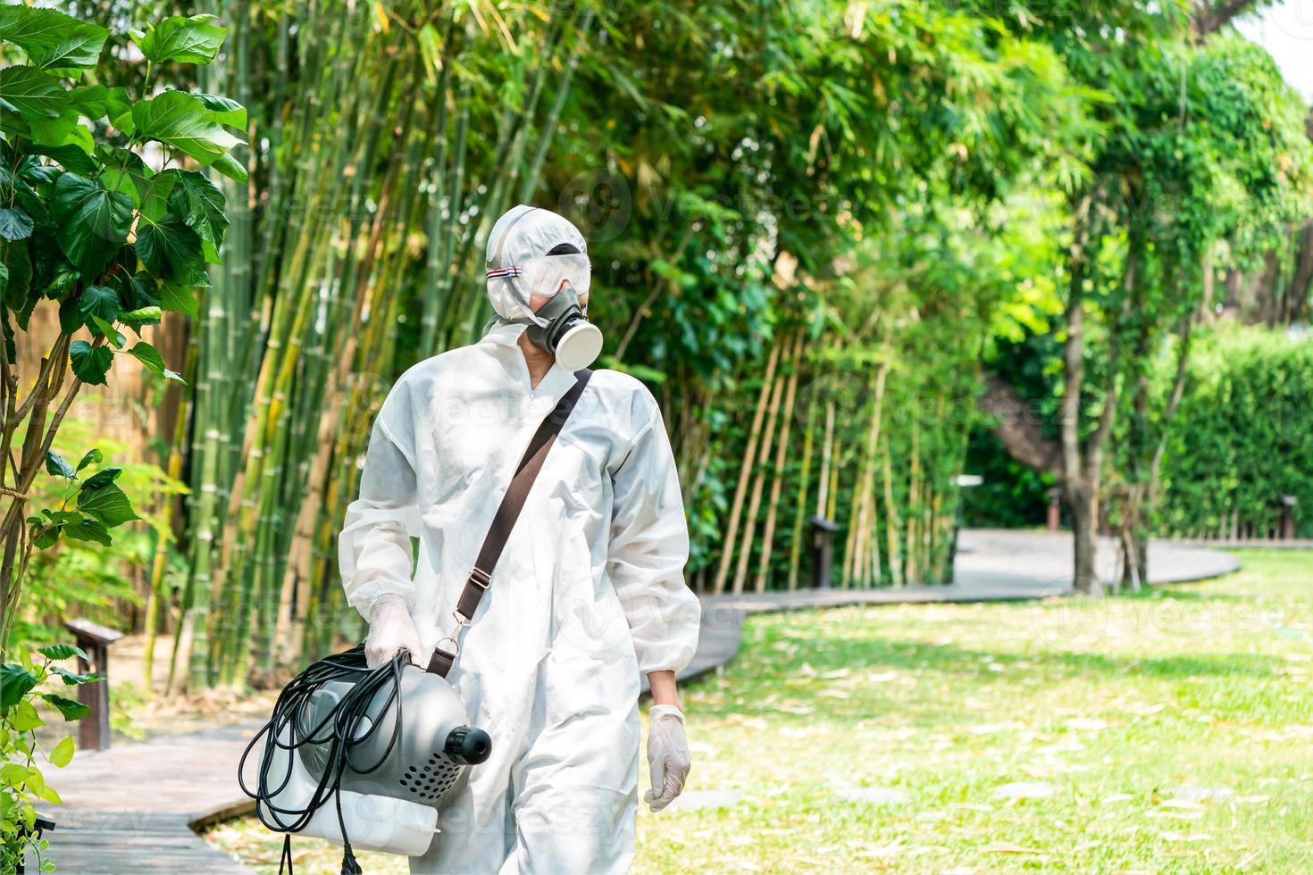 Professional specialist walking and observing around the outdoor garden to prepare spraying sanitizer liquid solution for kill Coronavirus COVID19. photo