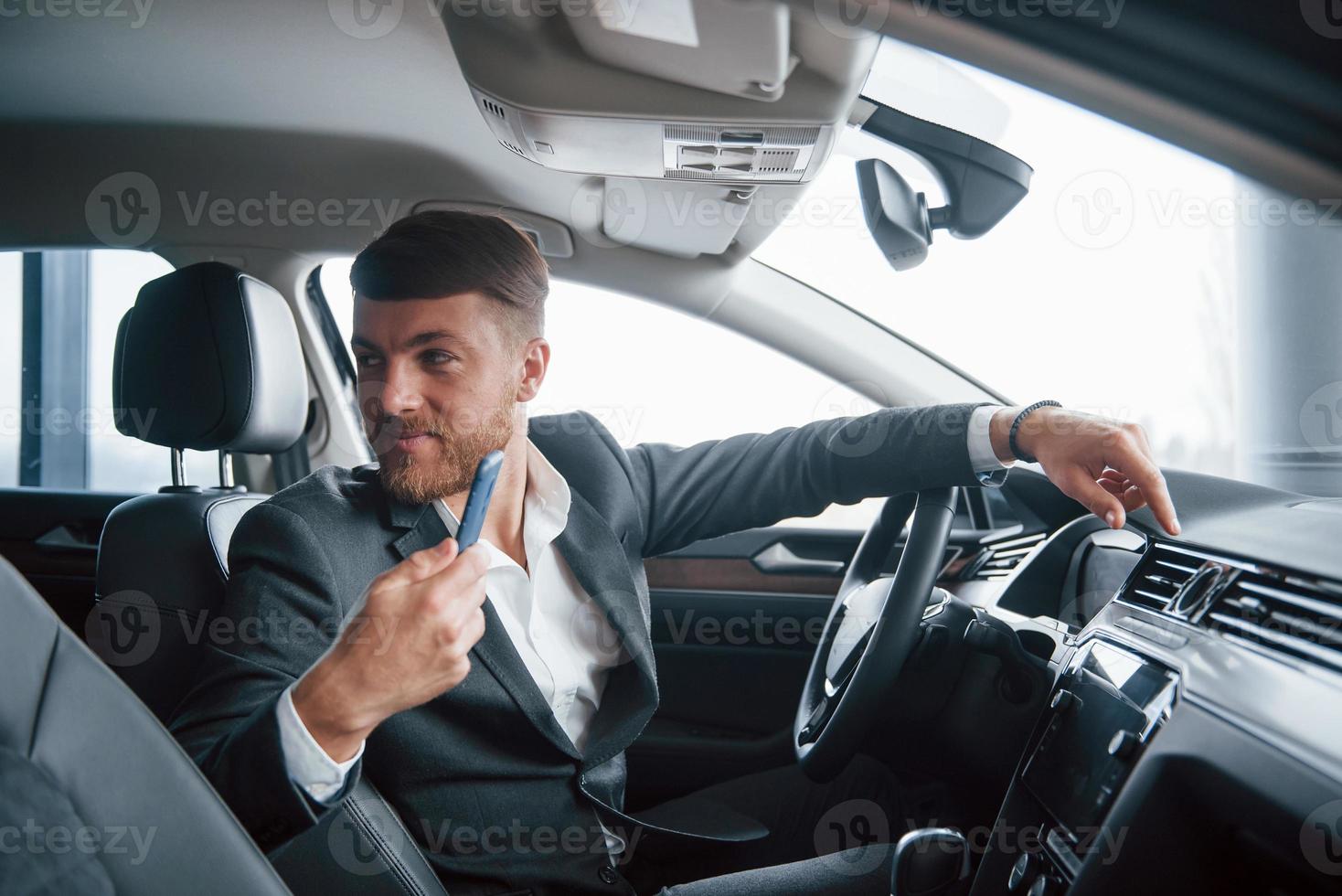 Passenger on back seat. Modern businessman trying his new car in the automobile salon photo