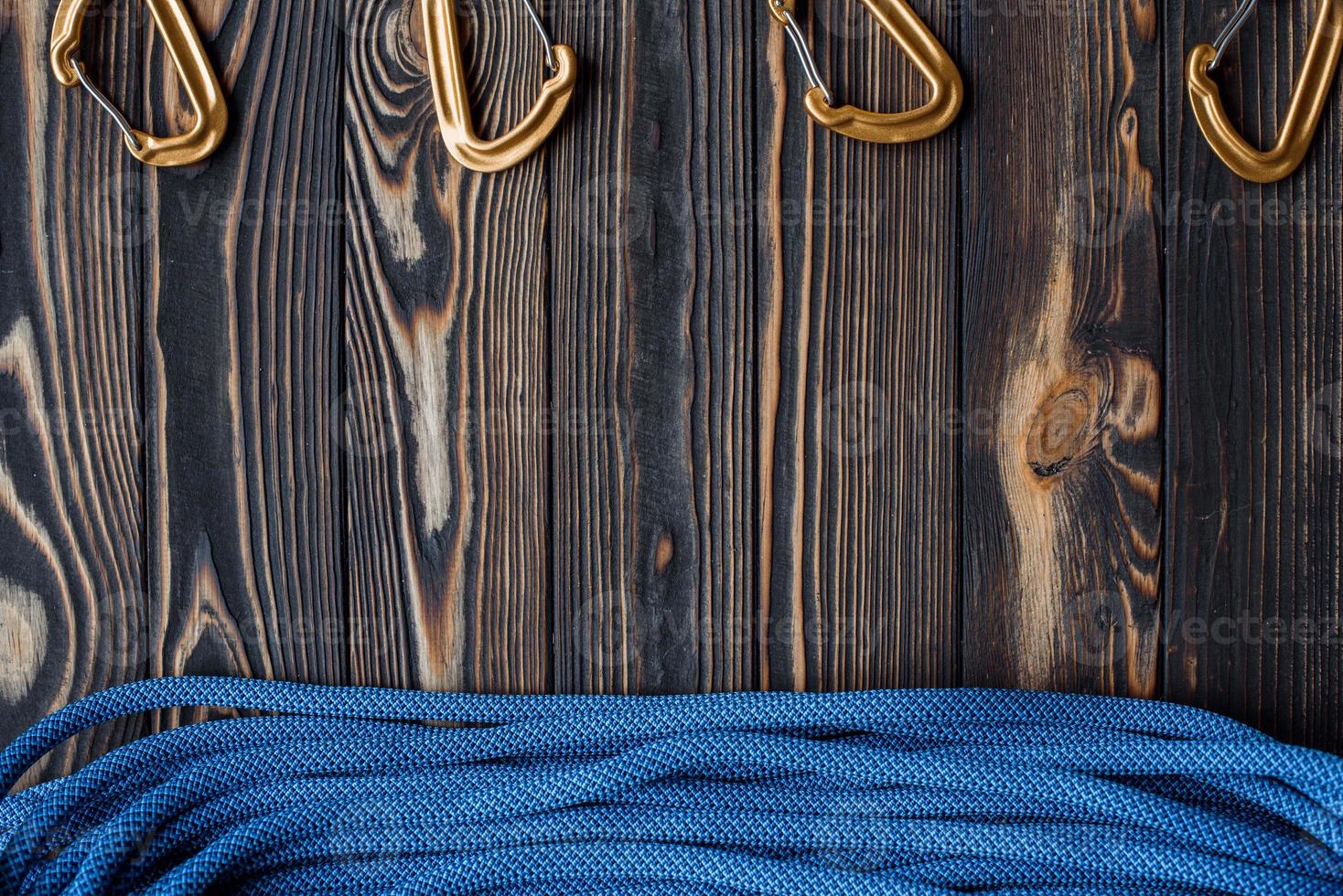 Different angle of view. Isolated photo of climbing equipment. Part of carabiner lying on the wooden table