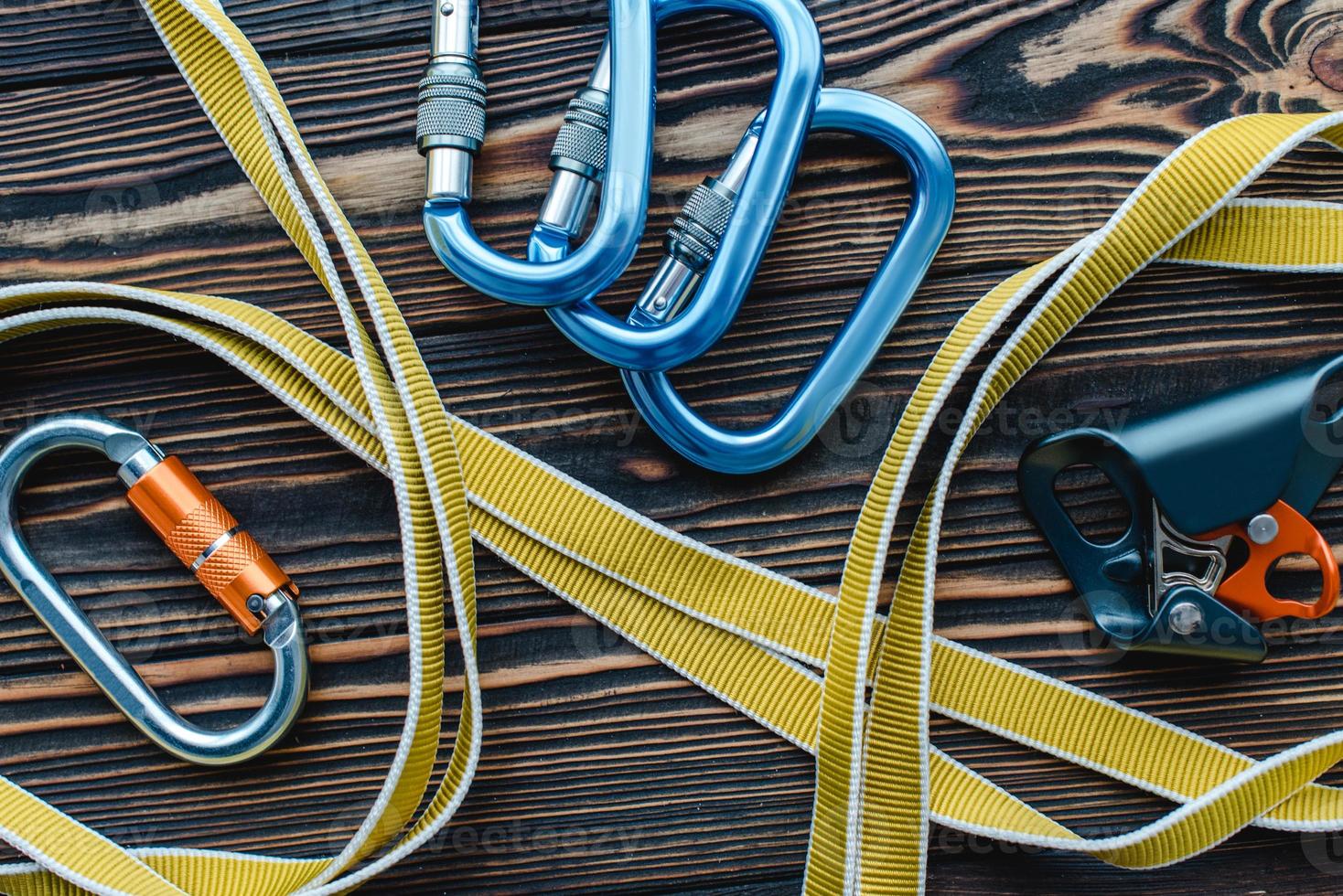 Stainless steel. Isolated photo of climbing equipment. Parts of carabiners lying on the wooden table