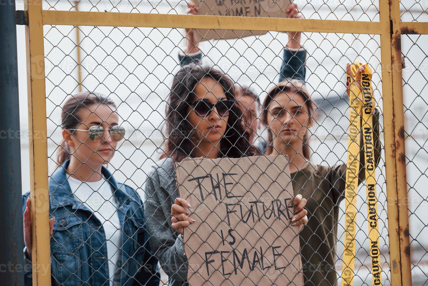 con cinta de precaución de color amarillo. grupo de mujeres feministas tienen protesta por sus derechos al aire libre foto