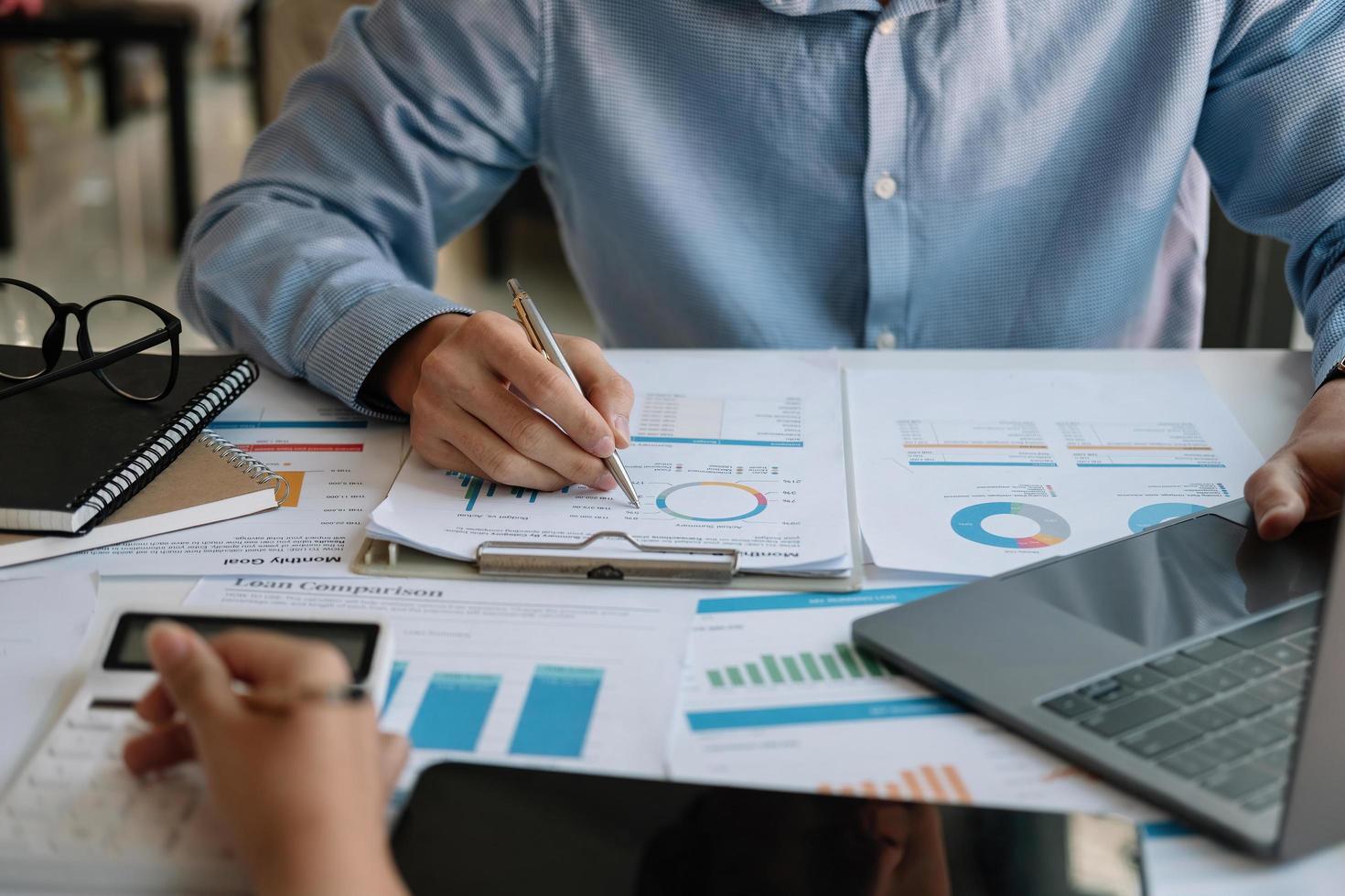 Close up Businessman and partner using calculator and laptop for calculating finance, tax, accounting, statistics and analytic research concept photo