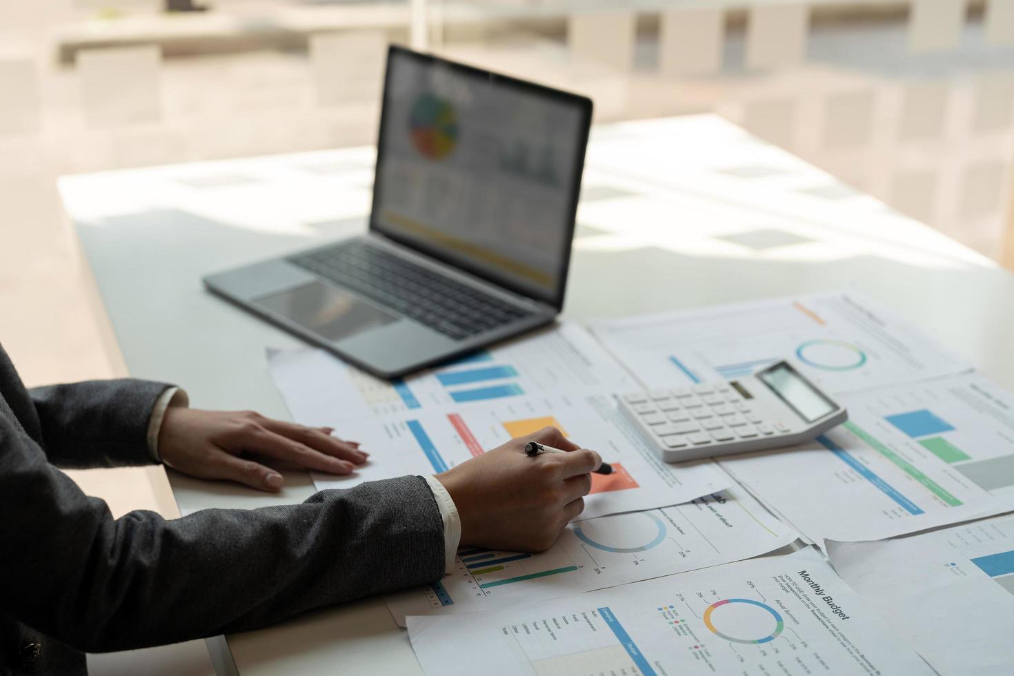 Businesswoman of bookkeeper working new plan financial graph data on laptop and doing finances, calculate investment and business strategy photo