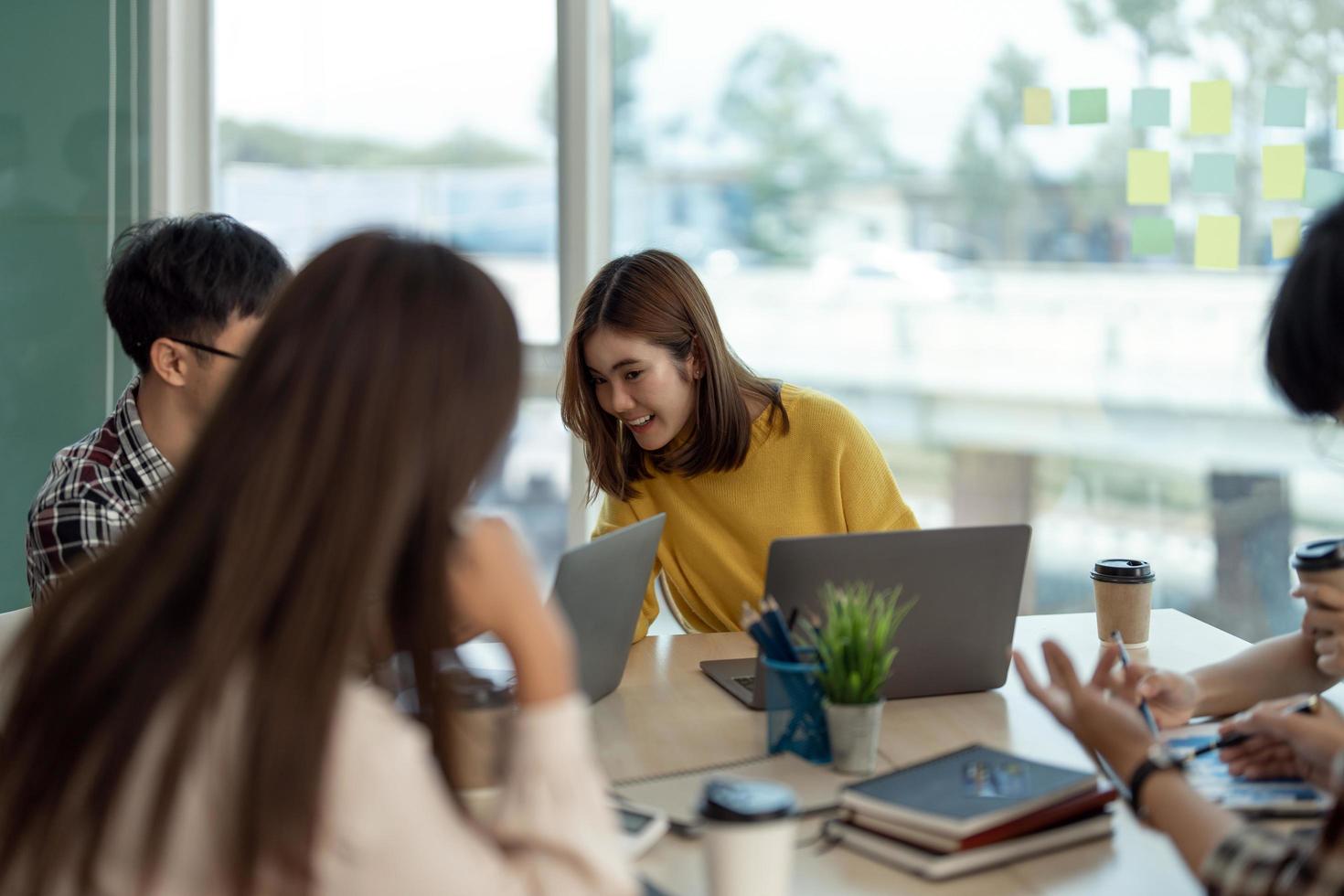 joven mujer asiática que lidera el equipo creativo de negocios en un proyecto de diseño de software de aplicaciones móviles. reunión de lluvia de ideas, trabajar juntos, tecnología de Internet, poder femenino, concepto de trabajo en equipo de compañeros de oficina. foto