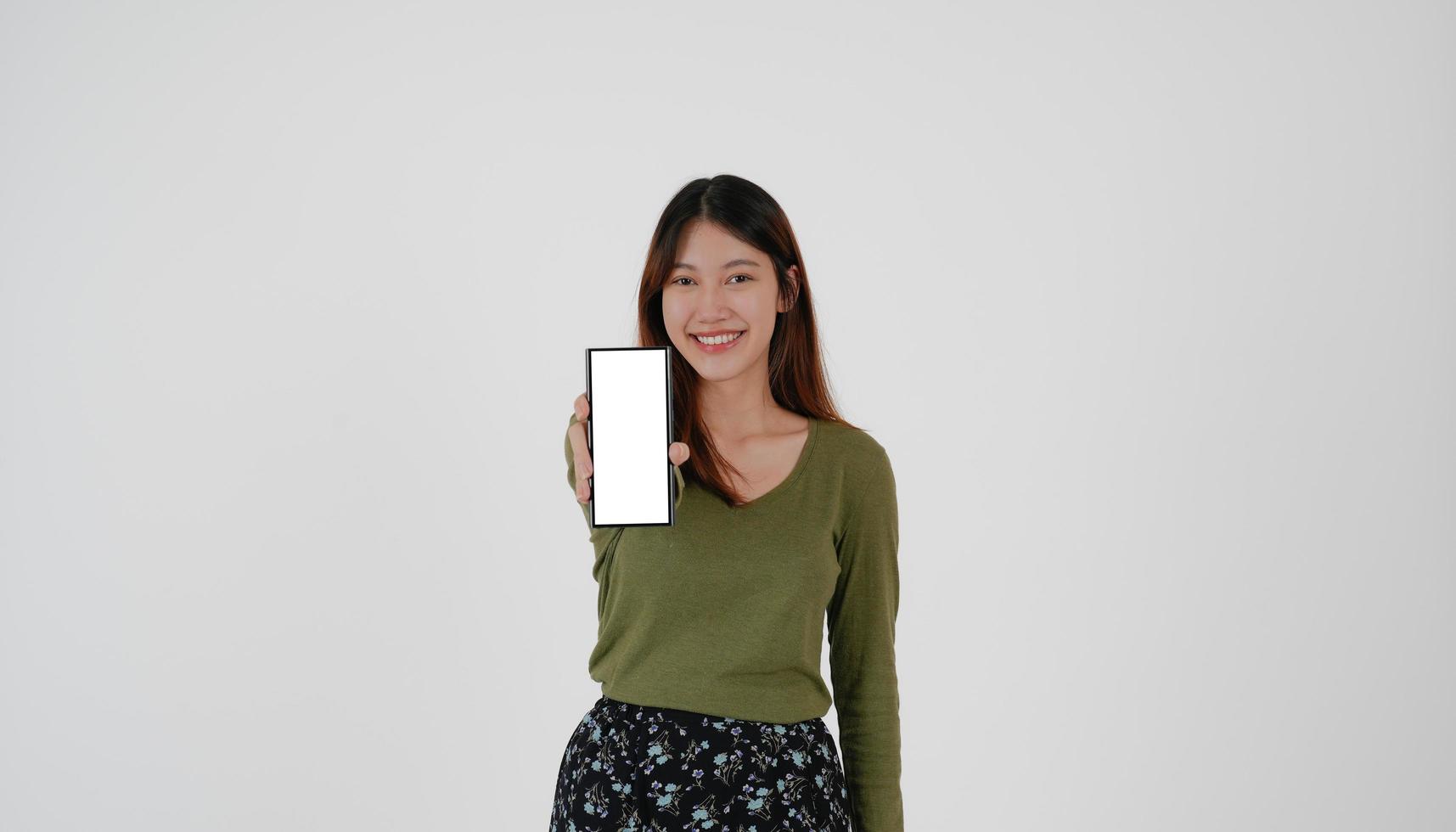 Image of young asian girl holding smartphone show blank white screen on white background. photo