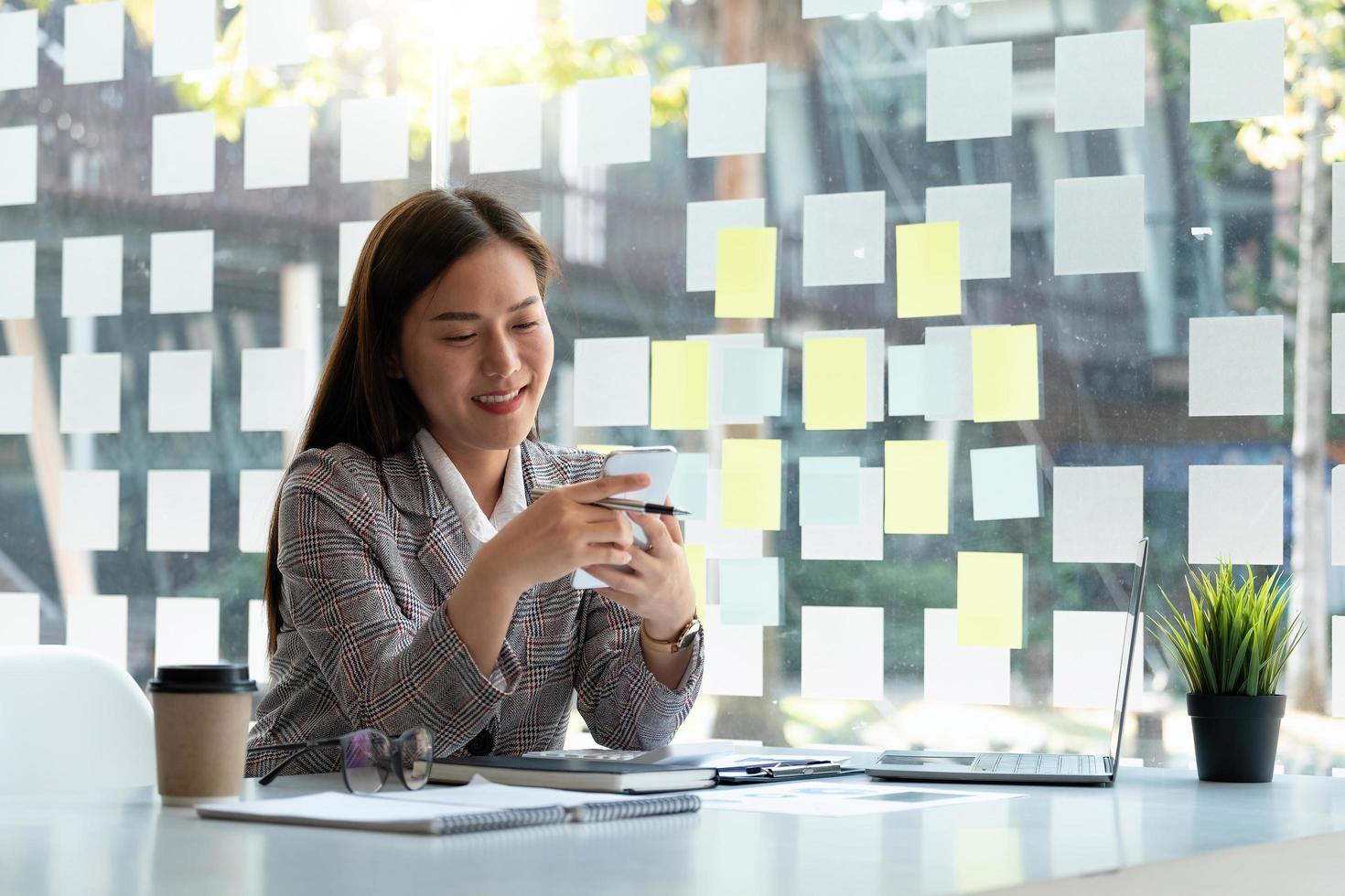 Business woman using mobile phone and laprop computer to calculate financial report and call banker for consult. photo