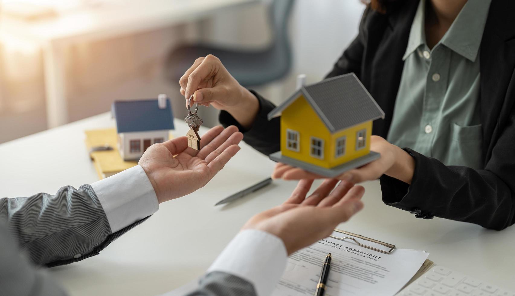 Man taking keys from female real estate agent during meeting after signing rental lease contract or sale purchase agreement. Independent woman purchasing new home photo