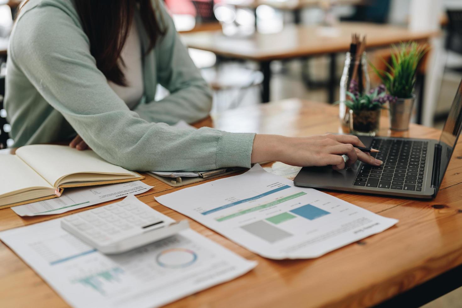 Business accountant woman using calculator for do math finance on wooden desk in office and business working background, tax, accounting, statistics and analytic research concept photo