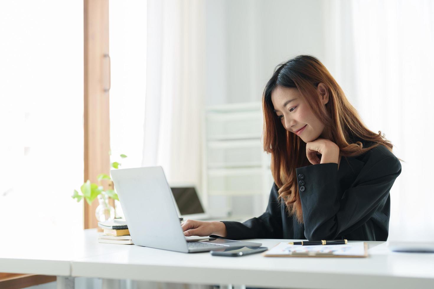 retrata a una mujer asiática usando una computadora portátil para un seminario web en línea o aprendiendo en casa. foto